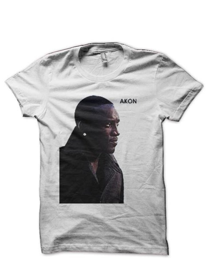 Akon in a white shirt smiling with his five kids.