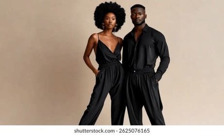 Both are dressed black while Jake is holding her and pointing to the camera.