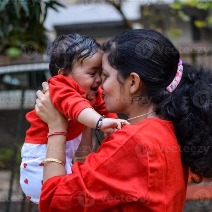 Her mom is holding her as she is surrounded by American flags.